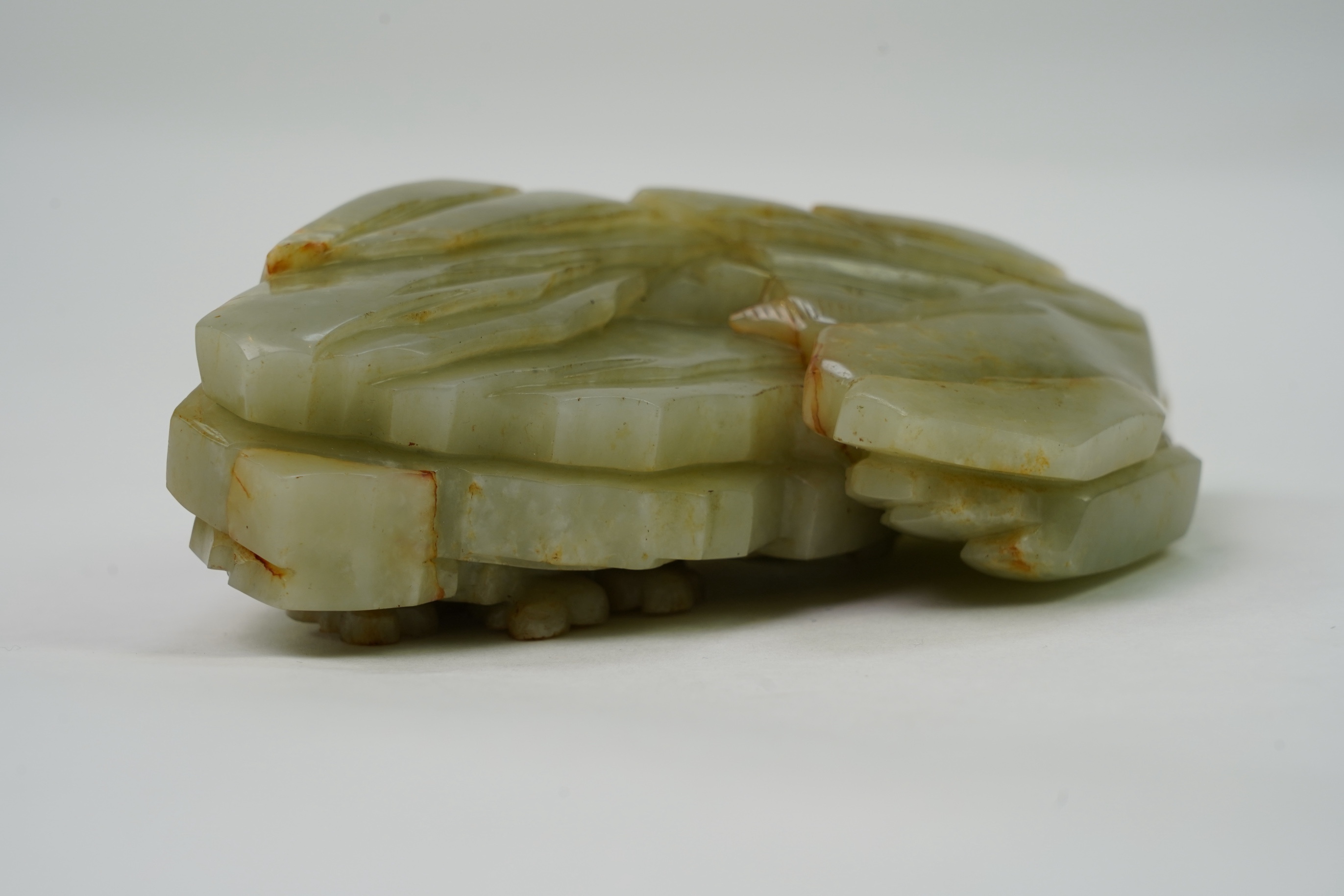 A Chinese celadon and russet jade boulder carving